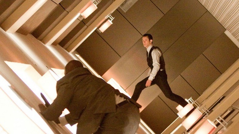 A tilting room with two men attempting to stand straight
