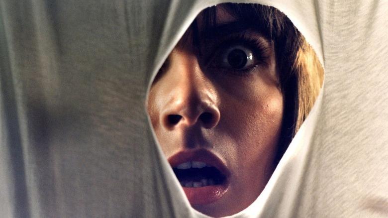 tenebrae woman stares through hole in fabric