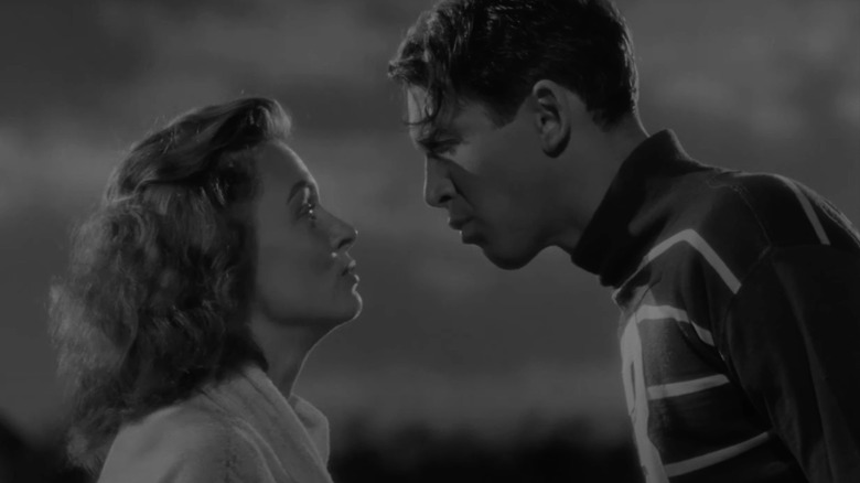 Donna Reed as Mary Bailey and James Stewart as George Bailey stare at each other in It's a Wonderful Life