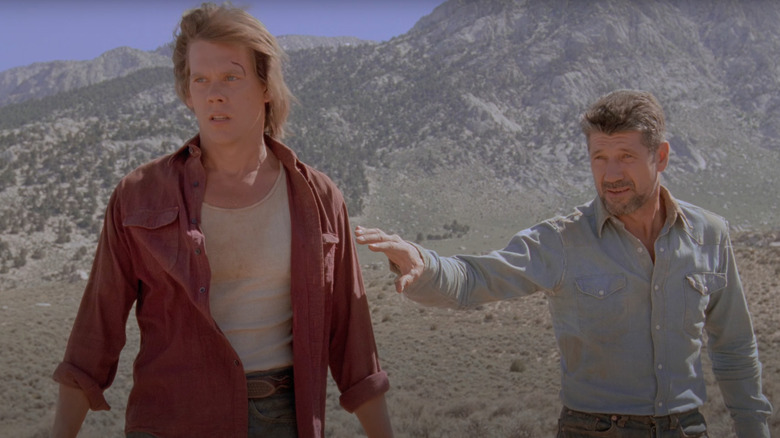 Kevin Bacon as Val and Fred Ward as Earl stand in the desert in Tremors