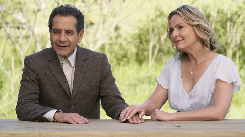 Monk and Trudy sit at a table in a park