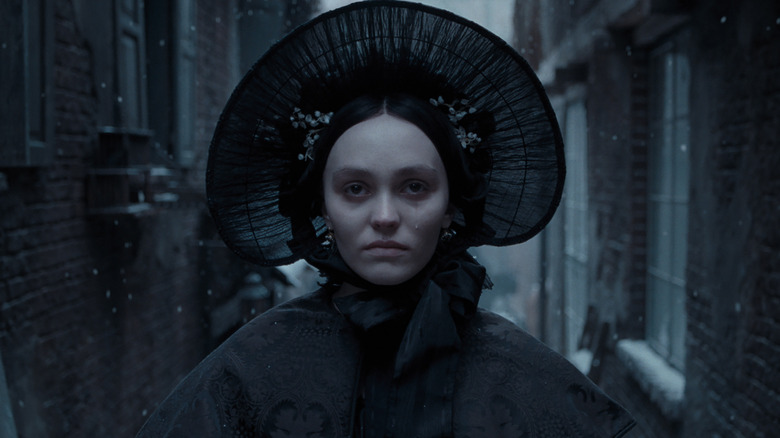 Ellen wears a giant hat and stands in the snow in Nosferatu (2024)