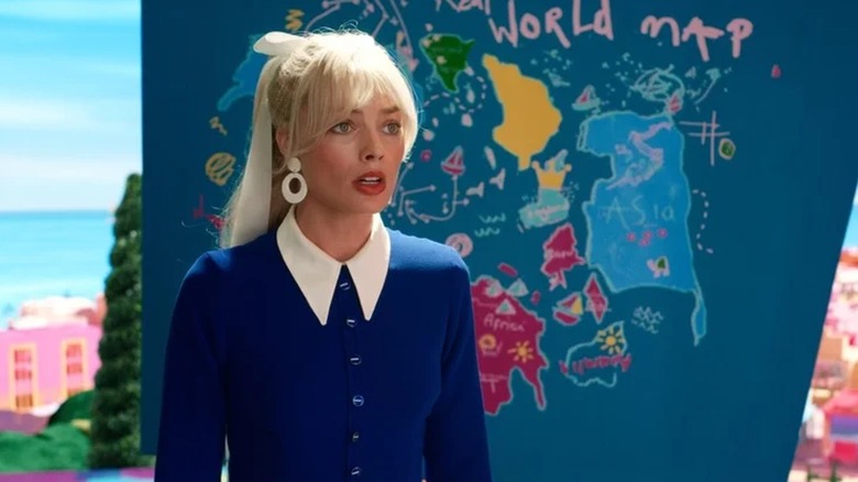 Margot Robbie standing in front of Weird Barbie's map in Barbie