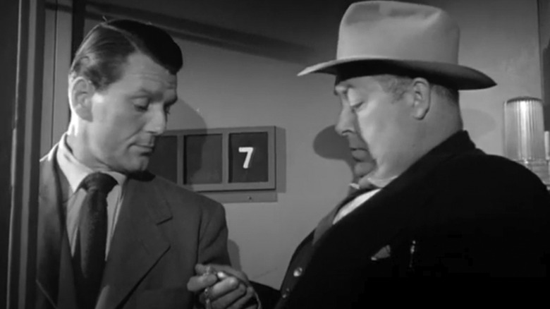 Detective Sgt. Brown and Sam Jennings look at a watch on board a train in The Narrow Margin