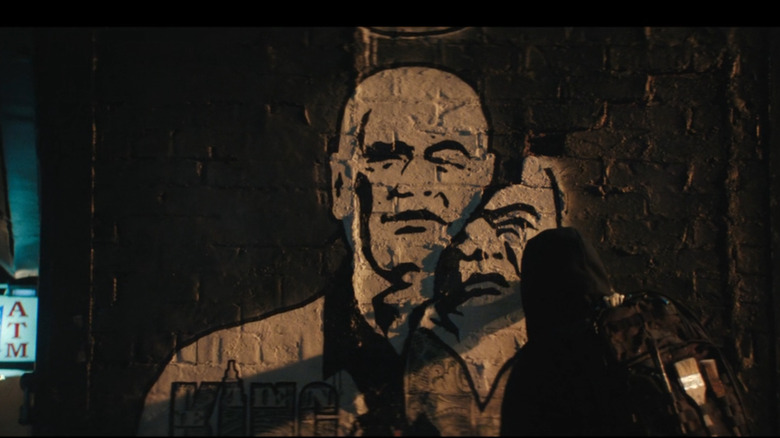 A hooded figure spray paints graffiti of Kingpin (Vincent D'Onofrio) on Daredevil: Born Again