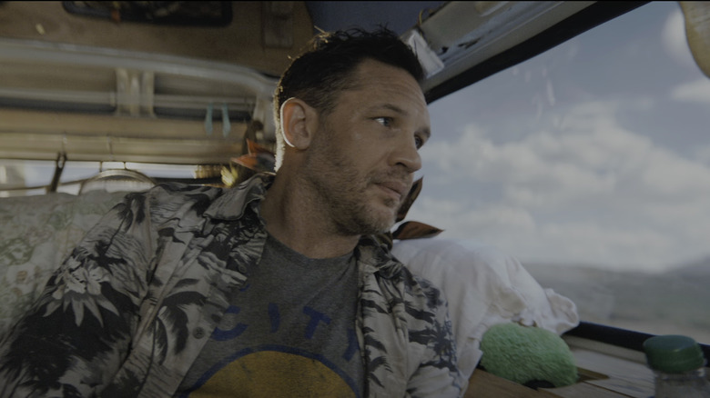 Tom Hardy Eddoo Brock looks at a truck window in poison in the last dance