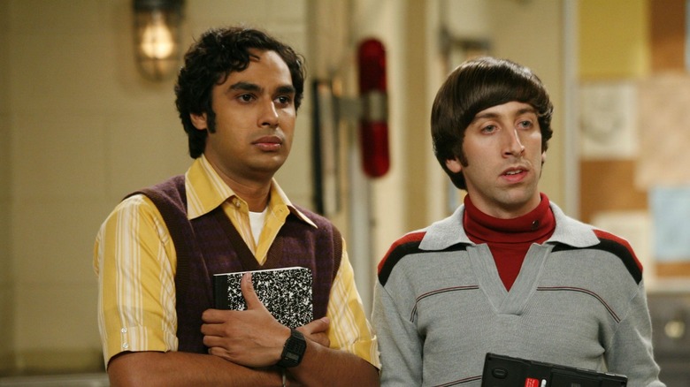 Raj segurando um caderno ao lado de Howard em The Big Bang Theory