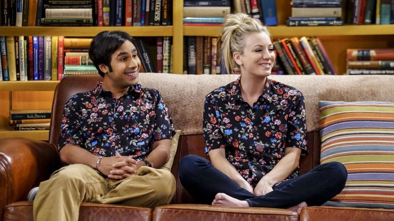 Raj and Penny in matching floral shirts sitting on the couch in The Big Bang Theory