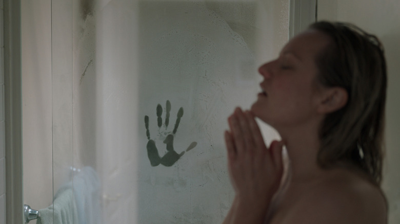 Elizabeth Moss as Cecilia takes a shower while a mysterious handprint appears in the background in The Invisible Man