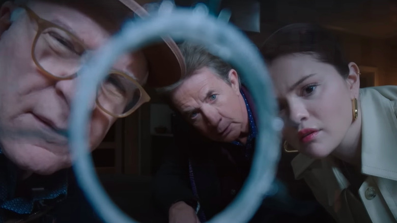 Steve Martin, Selena Gomez e Martin Short olham para um buraco de bala em uma janela na quarta temporada de Only Murders in the Building