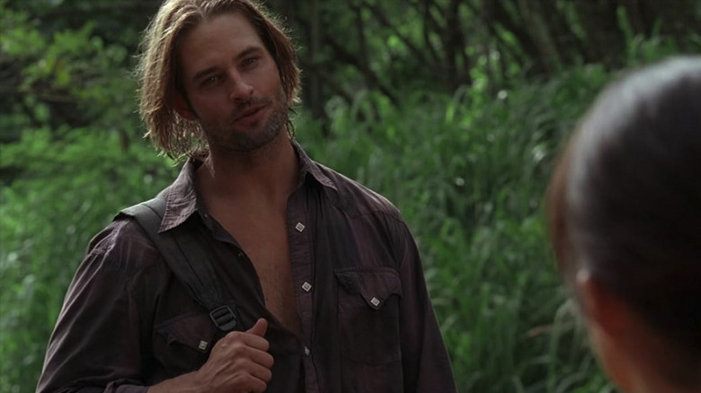 Sawyer with a backpack slung over his shoulder in the jungle, talking to Ana Lucia on Lost