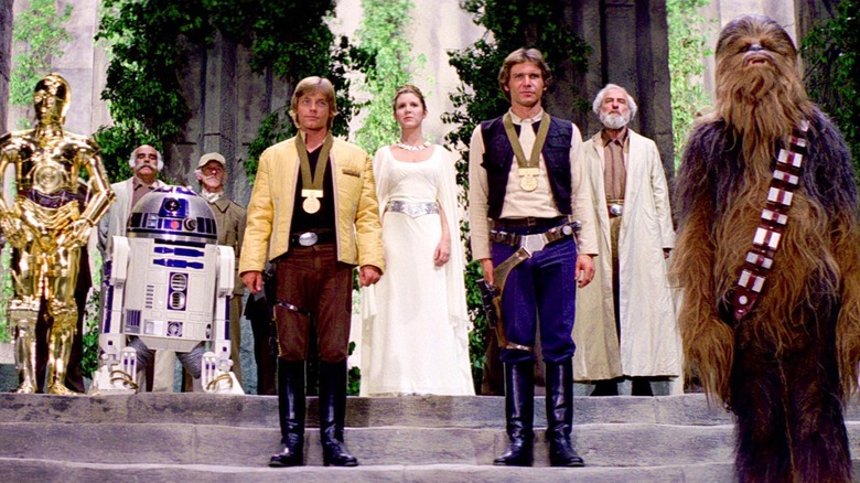 Luke, Han, and Chewie standing in front of the Rebel Alliance after receiving medals in Star Wars: A New Hope