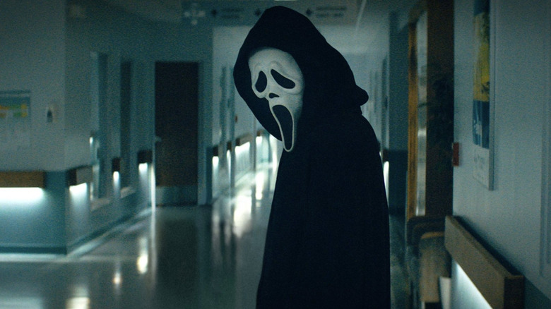 Ghostface standing in a corridor in Scream (2022)