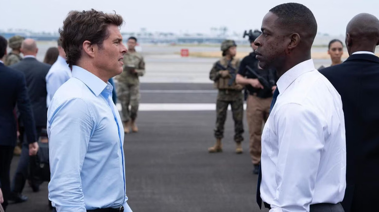 Cal and Xavier talking on a tarmac in Paradise