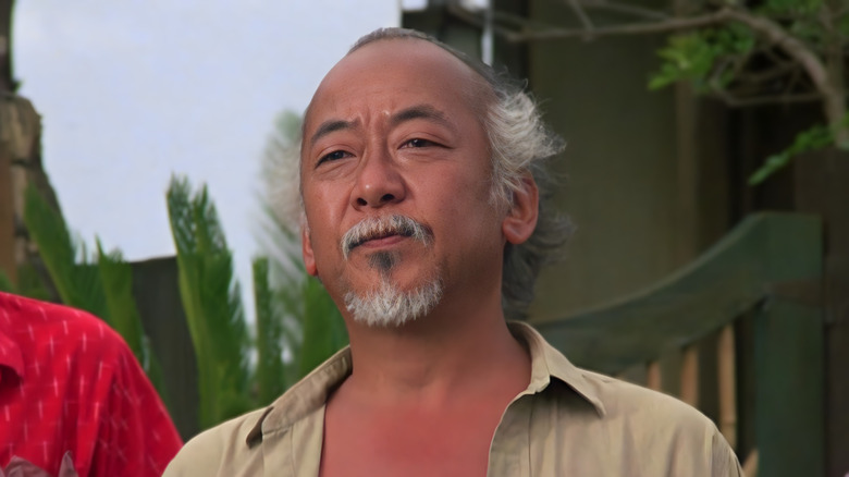 Mr. Miyagi smiling in a garden in The Karate Kid