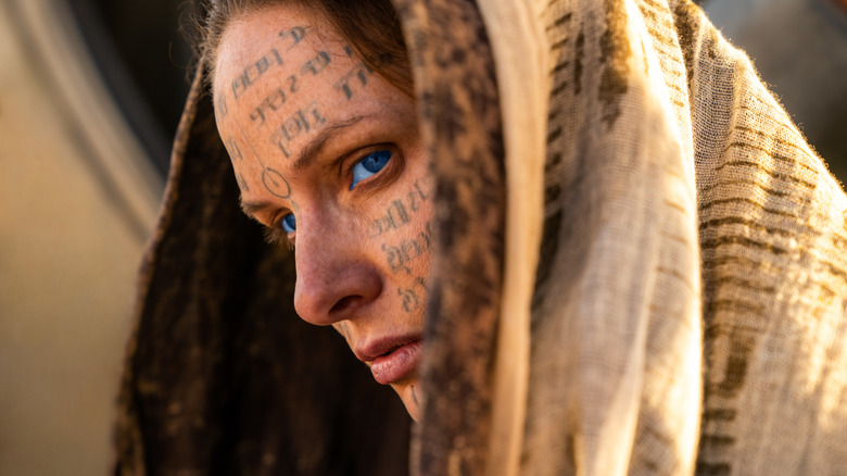 Lady Jessica in a hood with face tattoos looking mysterious in Dune: Part Two