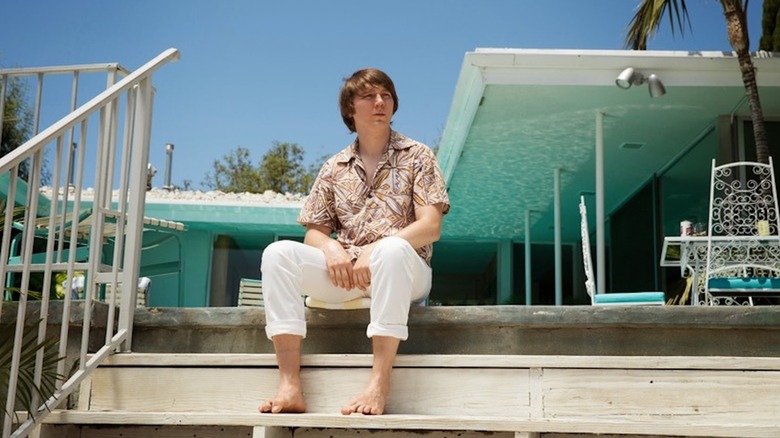 Paul Dano sits on poolside steps as Brian Wilson in Love & Mercy