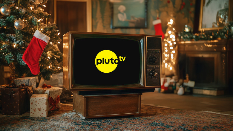 A television in front of a living room decorated for Christmas with Pluto TV on the screen