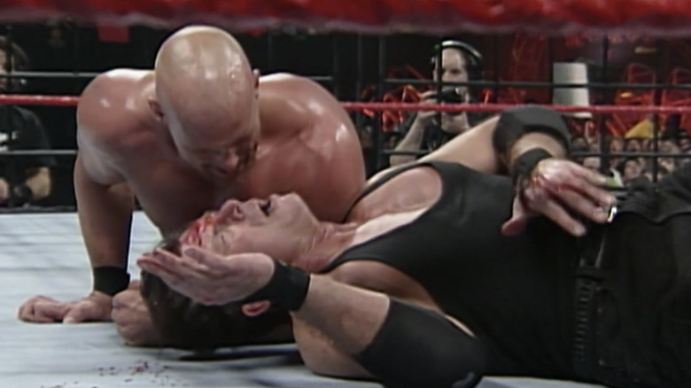 "Stone Cold" Steve Austin taunts a bloody Vince McMahon