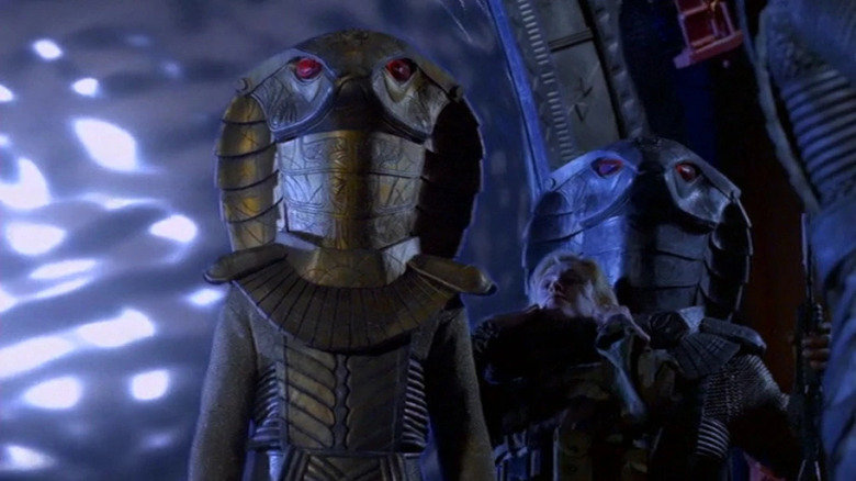 Os guardas de serpentes em pé em frente à esteira no Stargate: SG-1 Episódio Children of the Gods