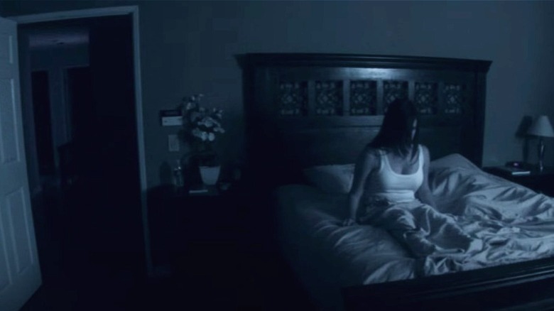 Katie sits in bed, seen in night vision footage