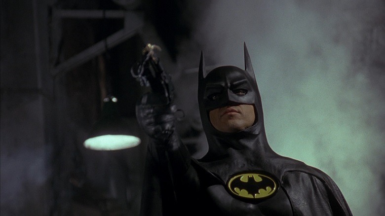 Batman fires his bat grappling gun