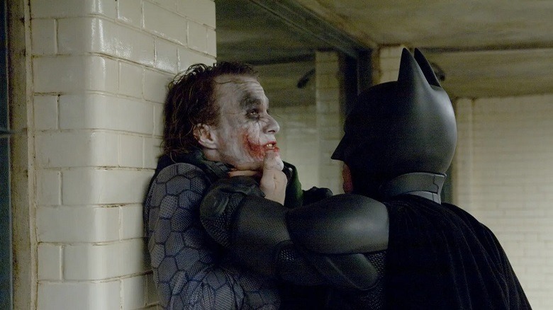 Batman holds the Joker against a wall