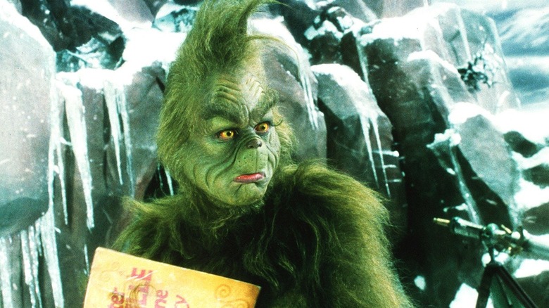 the grinch frowns holding book