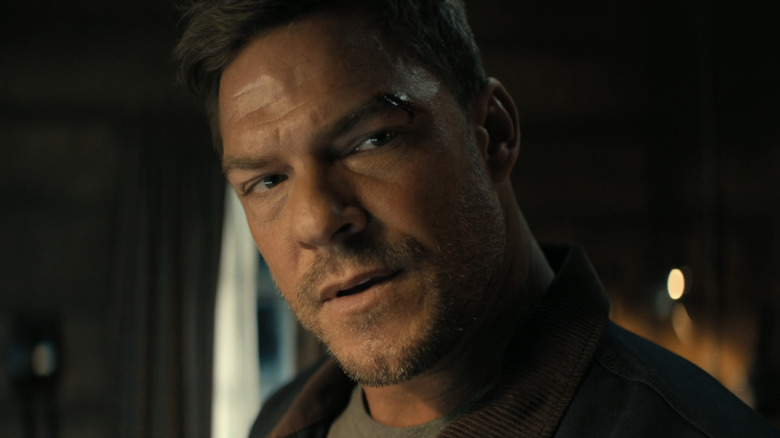 Alan Ritchson's Jack Reacher is shown in closeup with a face wound in Reacher