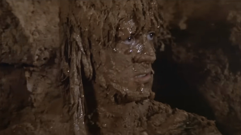 Sylvester Stallone's John Rambo is covered in mud in Rambo First Blood II