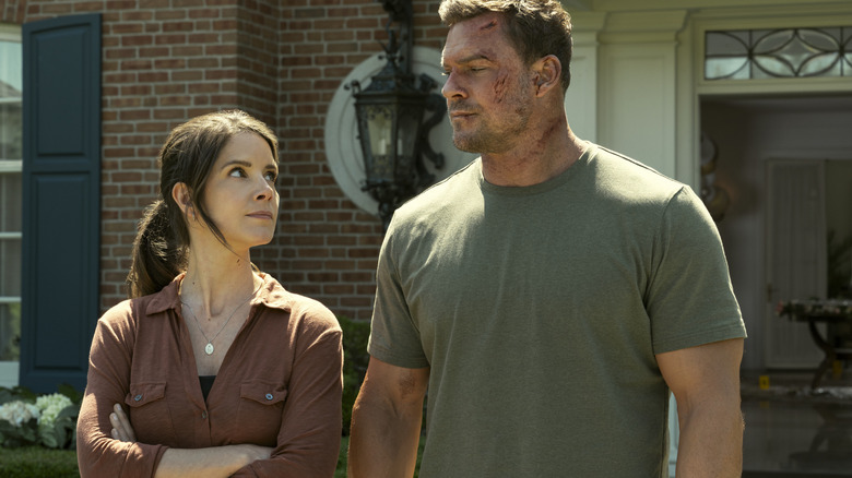 Sonya Cassidy como agente Susan Duffy e Alan Ritchson como Jack Reacher, fazendo os olhos um para o outro do lado de fora de uma casa de Boston na terceira temporada de Reacher