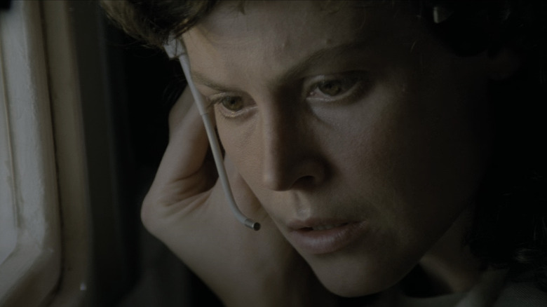 Ellen Ripley escucha atentamente una comunicación a través de su auricular extraterrestre