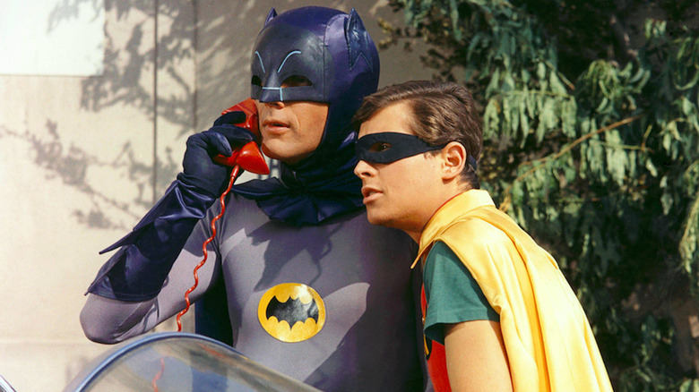 Batman on Batphone in Batmobile. Robin listens closely next to him. Scene from 1966 Batman.