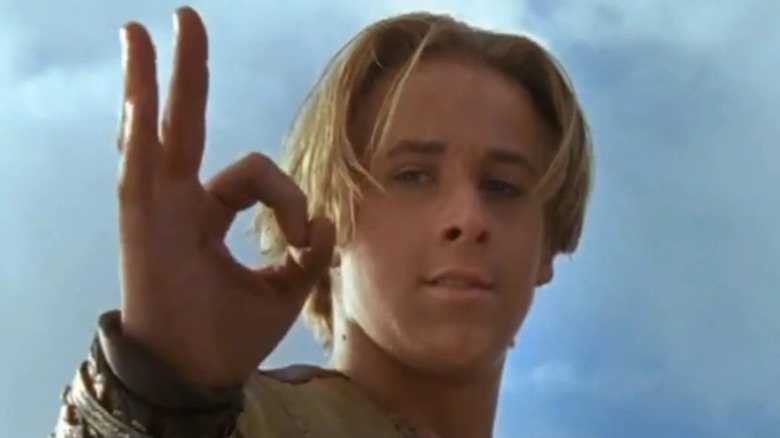 Ryan Gosling as Young Hercules, giving the OK sign with his right-hand thumb and index finger