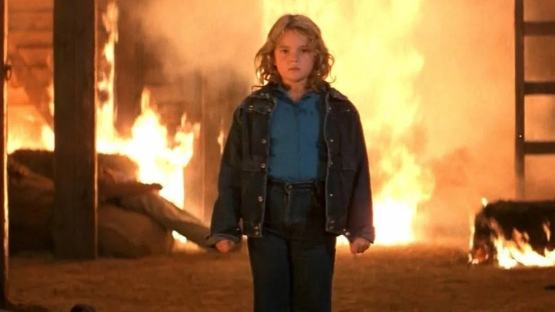 Charlie McGee (Drew Barrymore) emerges from a burning farmhouse in Firestarter (1984)