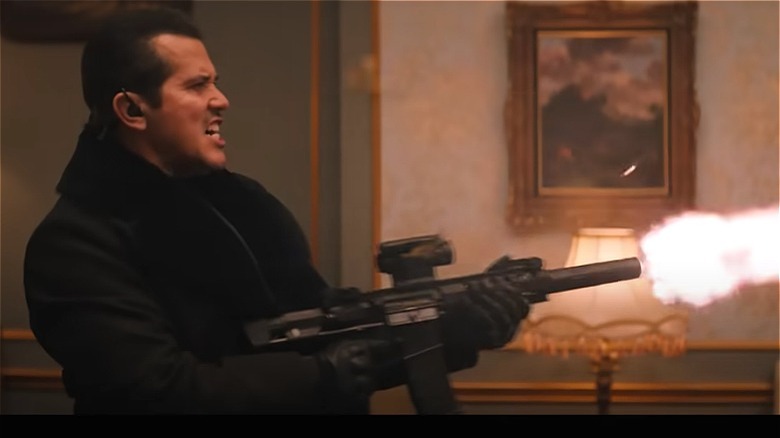 Violent Night's John Leguizamo fires a gun