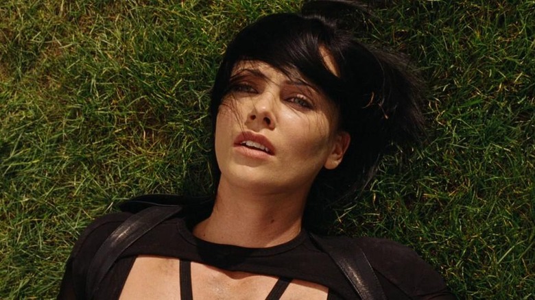 Charlize Theron laying in grass