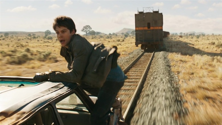 Dylan O'Brien climbing outside of moving car