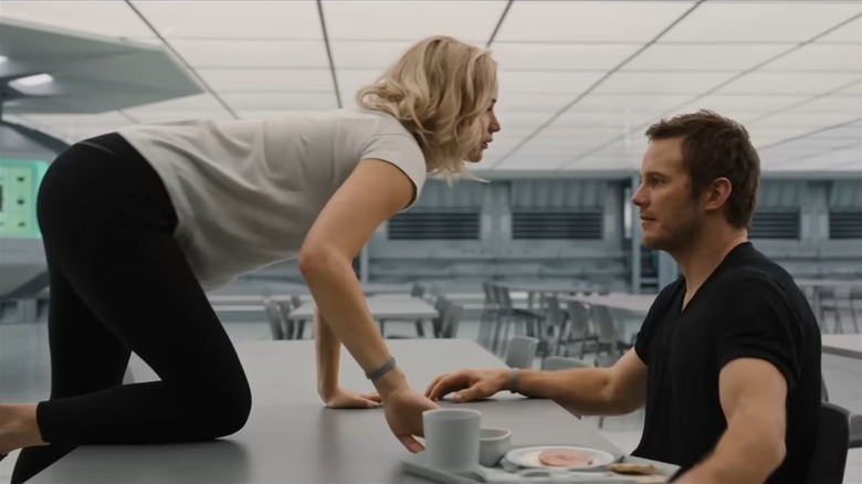 Jennifer Lawrence climbing on a table in front of Chris Pratt