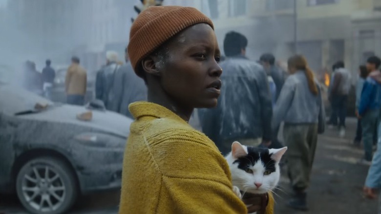 Sam holding her cat amidst people in A Quiet Place: Day One