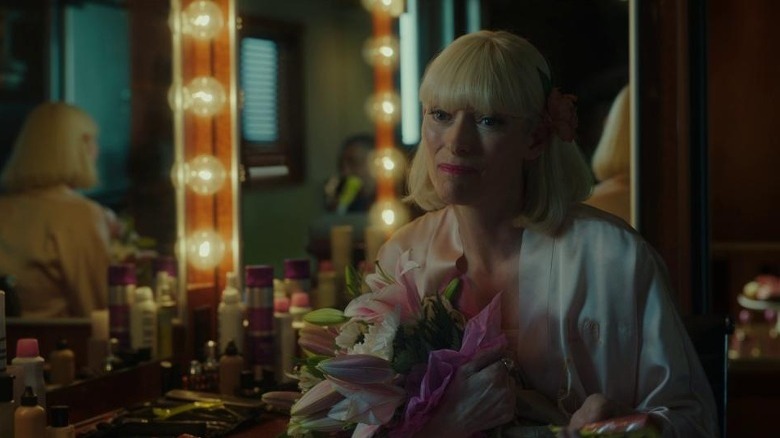 Tilda Swinton as Lucy Mirando holding flowers in dressing room in Okja