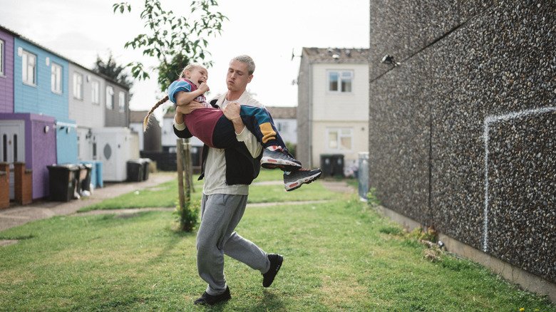 Harris Dickinson's Jason carries Lola Campbell's Georgie