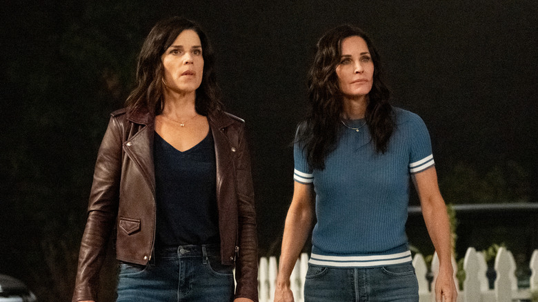 Neve Campbell as Sidney Prescott and Courteney Cox as Gale Weathers standing side by side in Scream (2022)