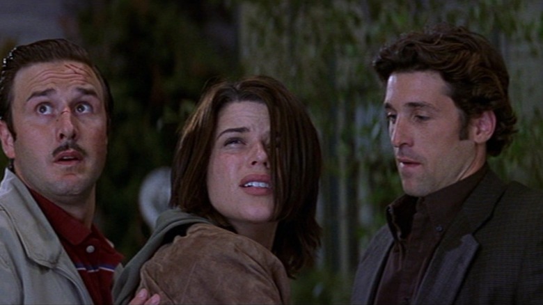 David Arquette as Dewey Riley, Neve Campbell as Sidney Prescott, and Patrick Dempsey as Mark Kincaid looking concerned in a scene from Scream 3