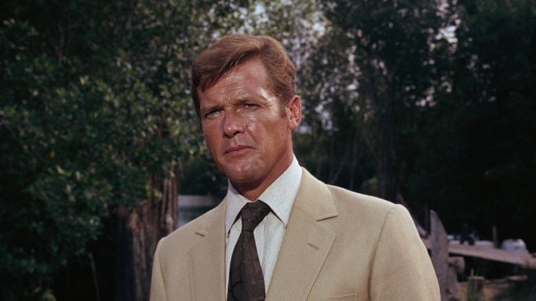 Roger Moore's James Bond stands in a tan suit in Live and Let Die