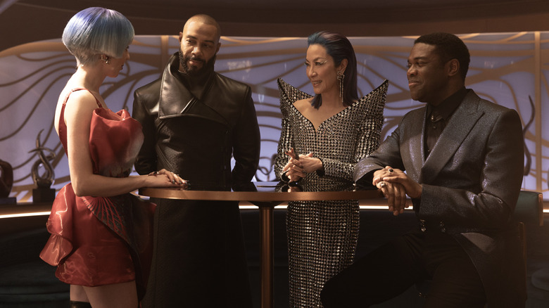 Kacey Rohl sebagai Rachel, Omari Hardwick sebagai Alok, Michelle Yeoh sebagai Georgiou, dan Sam Richardson sebagai Quasi berdiri di dekat meja di Star Trek: Bagian 31