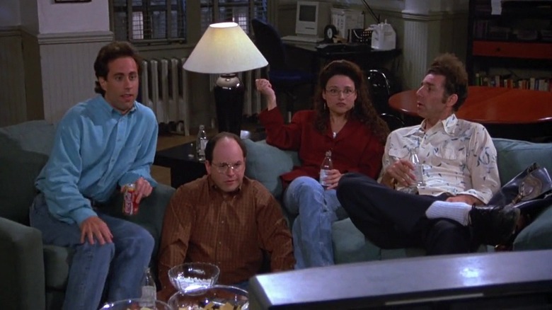 Jerry Seinfeld, George Costanza, Elaine Benes, and Cosmo Kramer looking concerned while watching television on Seinfeld