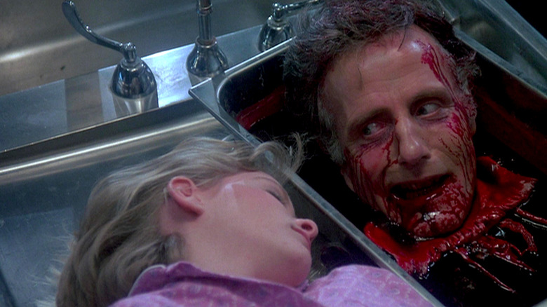 Dr. Hill's severed head stares at an unconscious Megan