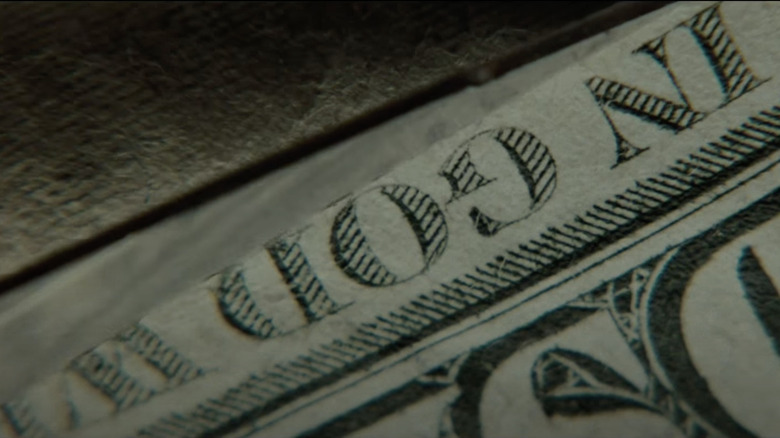 Seven opening titles "God" on dollar bill