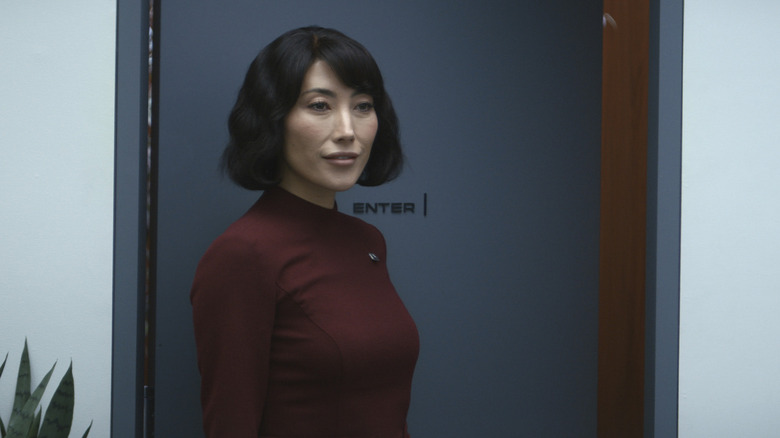 Dichen Lachman as Ms. Casey/Gemma standing outside her office door in Severance season 1